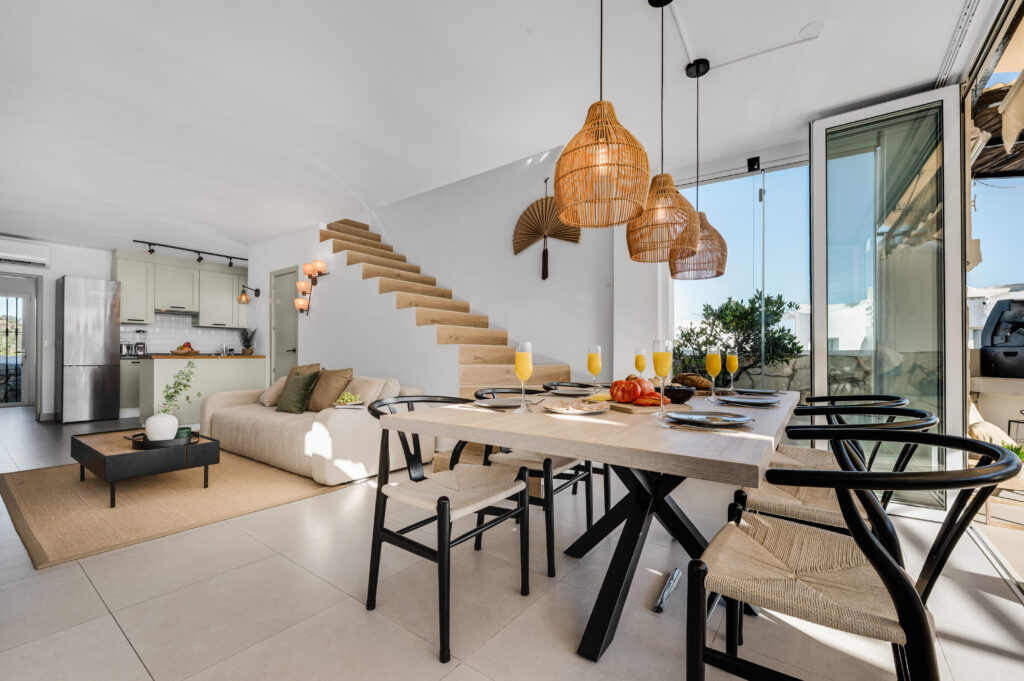 Open-plan living and dining area with the staircase and terrace doors