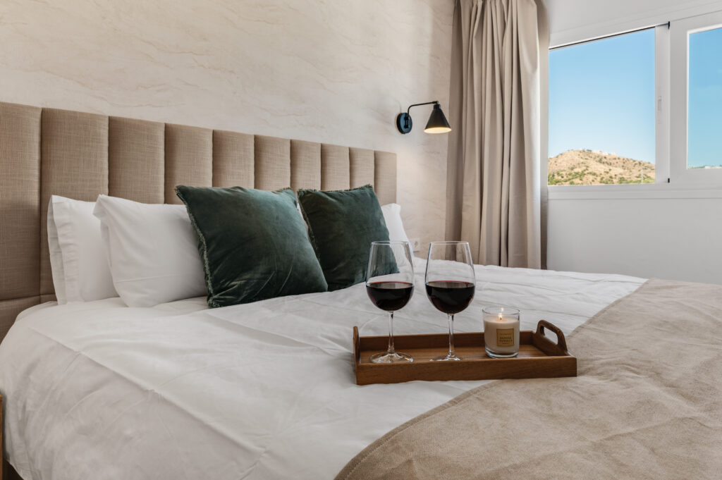 Master bedroom with upholstered headboard and a morning tray
