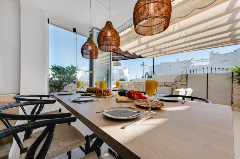 Dining table laid for six with the terrace doors open