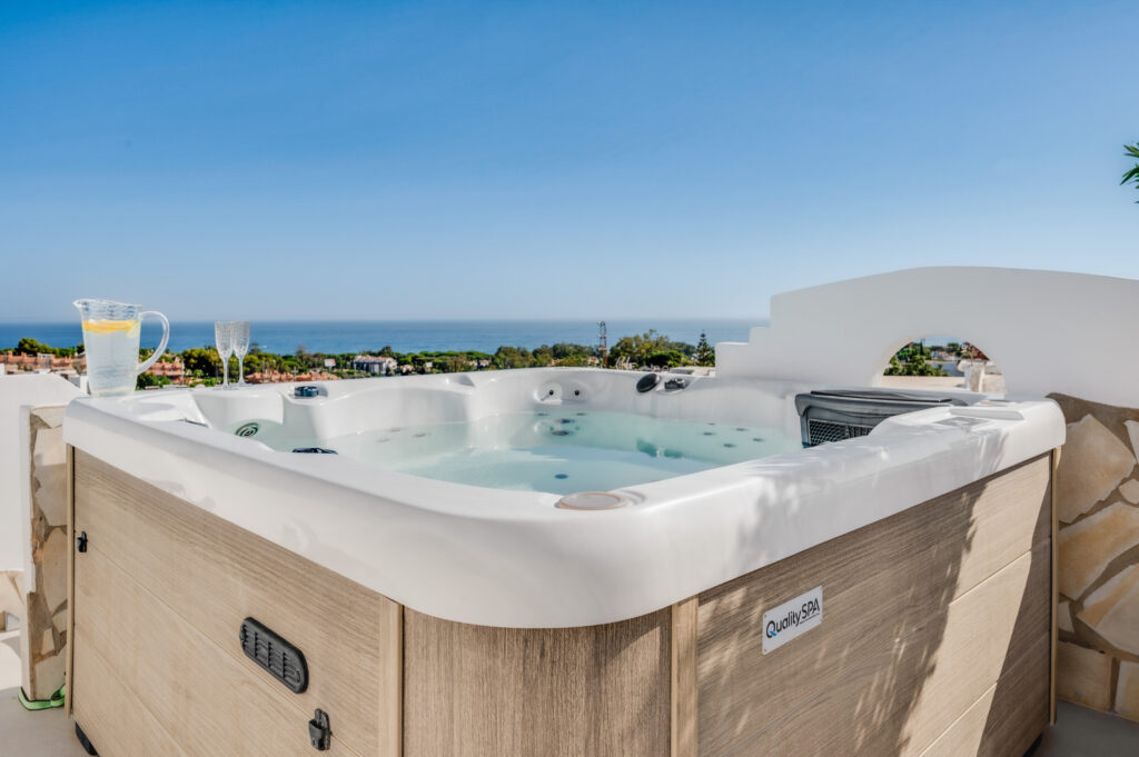 Rooftop jacuzzi with drinks on the rim and the sea beyond