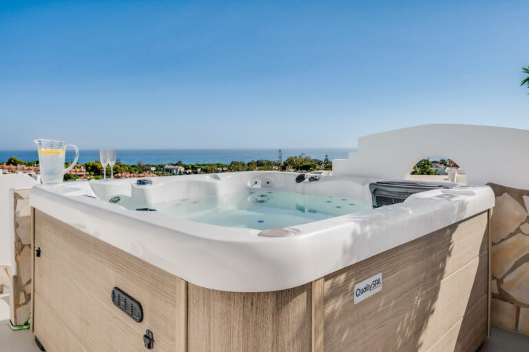 Rooftop jacuzzi with drinks on the rim and the Mediterranean beyond