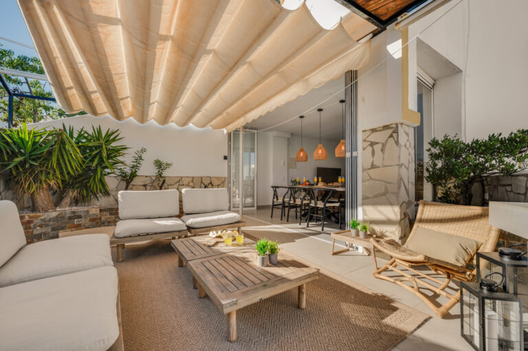 Terrace lounge under the pergola, looking back into the house