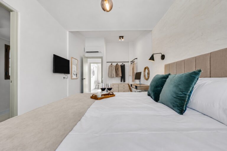 Master bedroom with an open wardrobe and a workspace with an external monitor