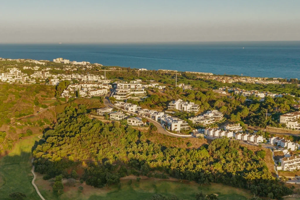 Aerial view at sunset over Artola and Cabopino in Marbella East, with white houses, pine woods, a golf fairway and the Mediterranean beyond