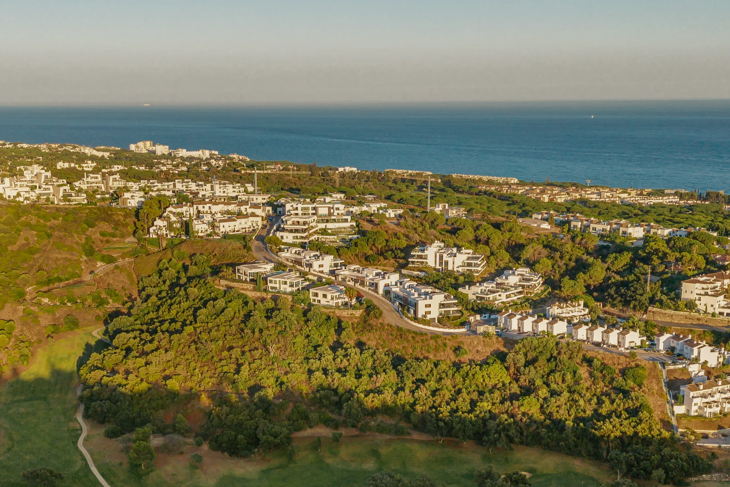 Artola and Cabopino from the air at sunset, with the Mediterranean beyond