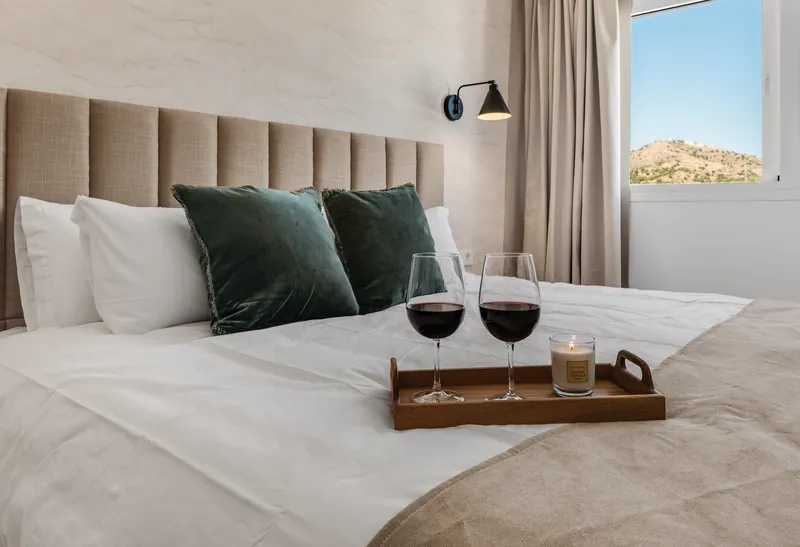 Master bedroom made up as one large double bed, with a tray of glasses on the bedspread